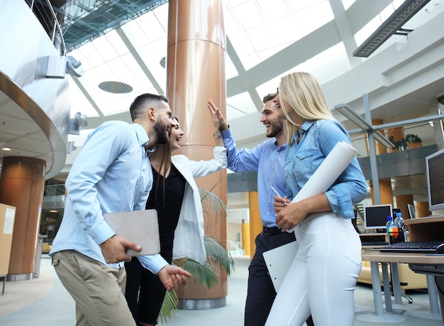 Zakelijk team viert succes met high-five in modern kantoor